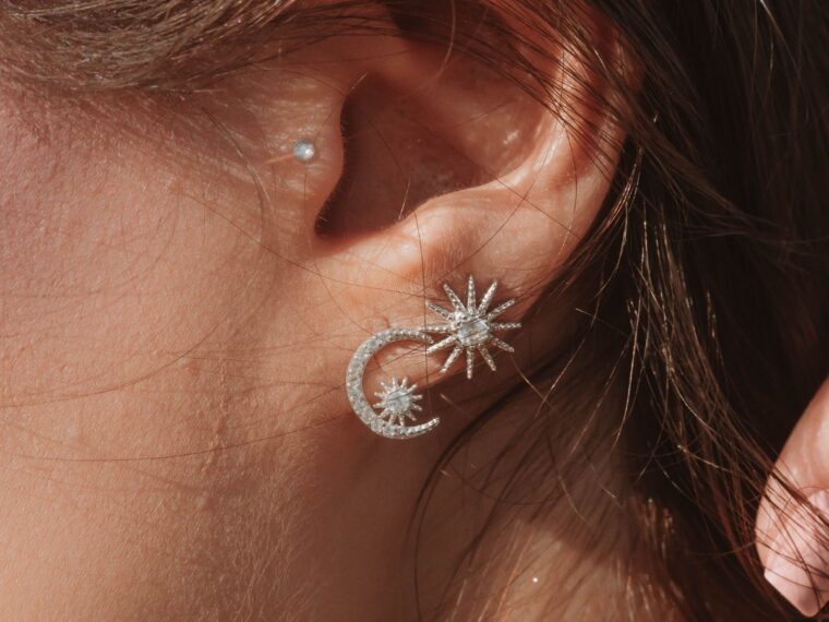 A girl wearing celestial themed silver earrings