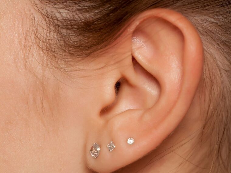 A girl with three piercings on her lobe.